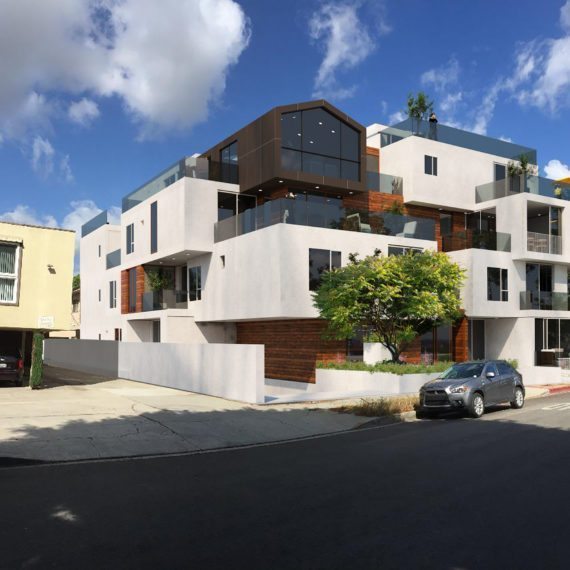Modern white residential building with balconies and dark accents under a blue sky.