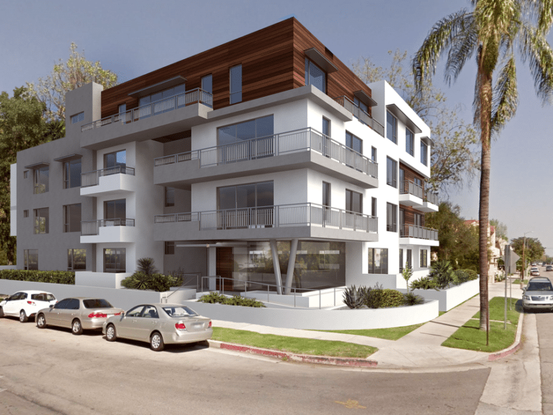 Modern multi-story apartment building with balconies and surrounding greenery.