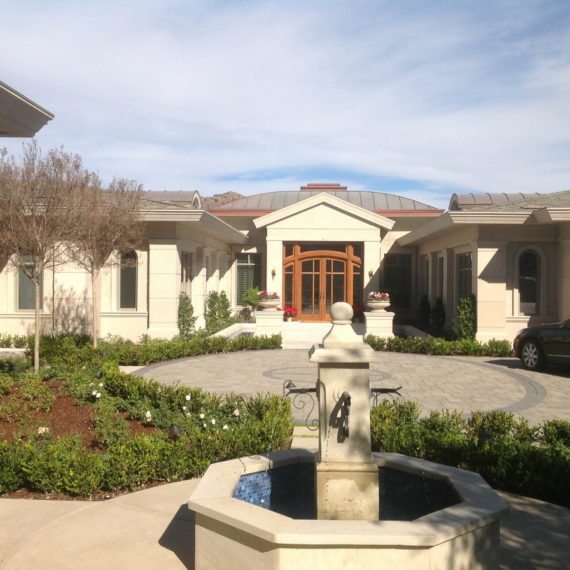 Sunny courtyard with a central fountain and surrounding garden beds.