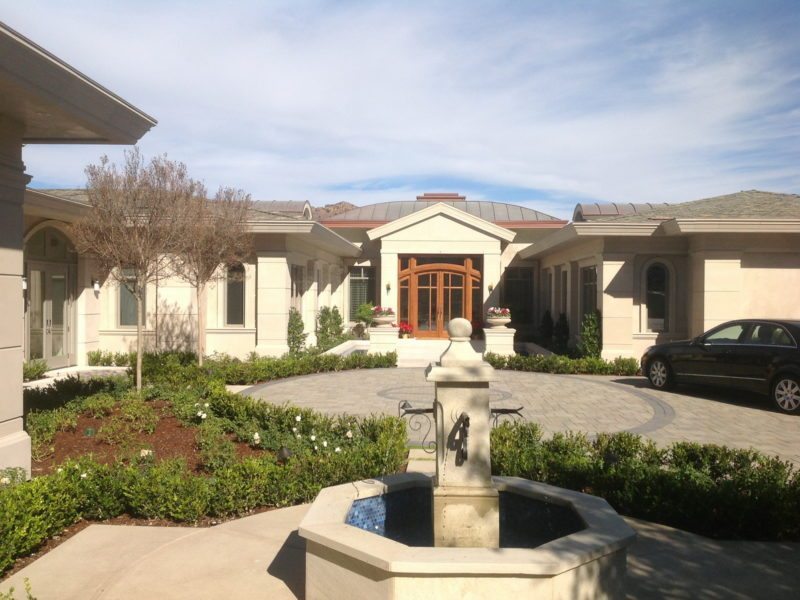 Sunny courtyard with a central fountain and surrounding garden beds.
