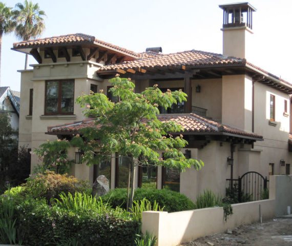A Mediterranean-style house with a tiled roof and chimney.