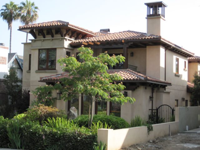 A Mediterranean-style house with a tiled roof and chimney.