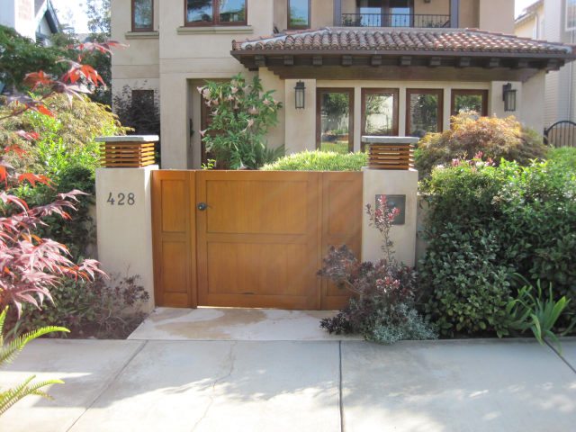 Modern wooden gate with a sleek design in front of a residential building.