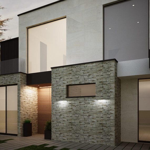 Modern townhouse exterior with stone and stucco walls illuminated at night.