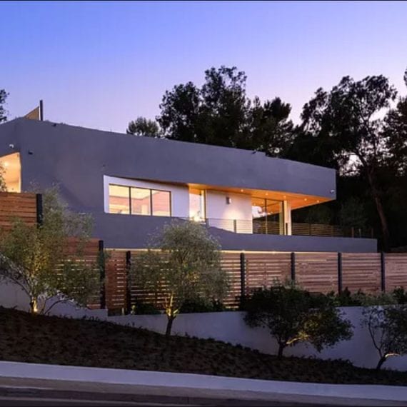 Modern house with large windows illuminated at dusk.