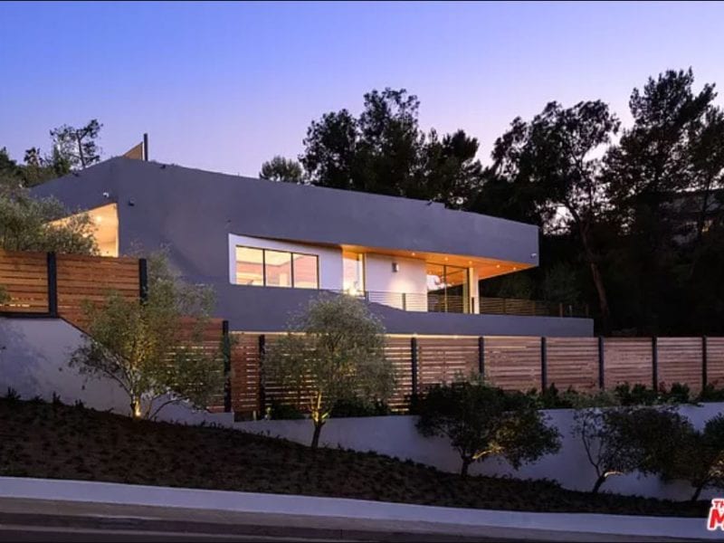 Modern house with large windows illuminated at dusk.