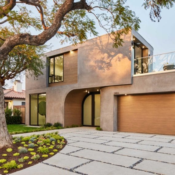 Modern two-story house with a large garage and landscaped yard.