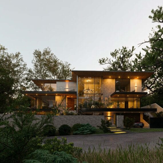 Modern two-story house illuminated at dusk with surrounding trees.
