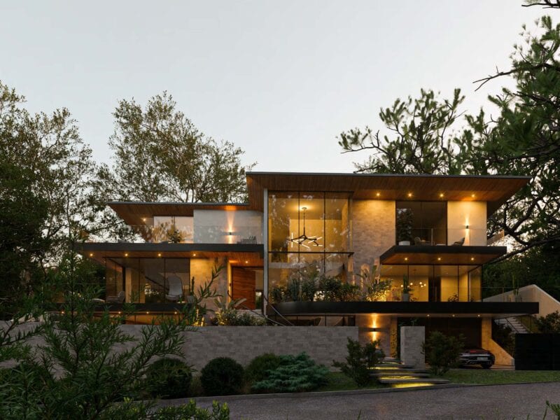 Modern two-story house illuminated at dusk with surrounding trees.
